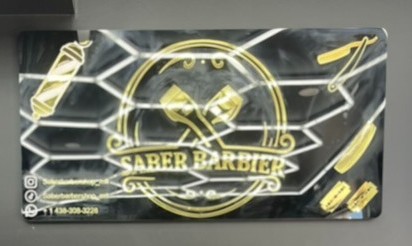 Panneau enseigne noir avec lettrage doré pour un barbier