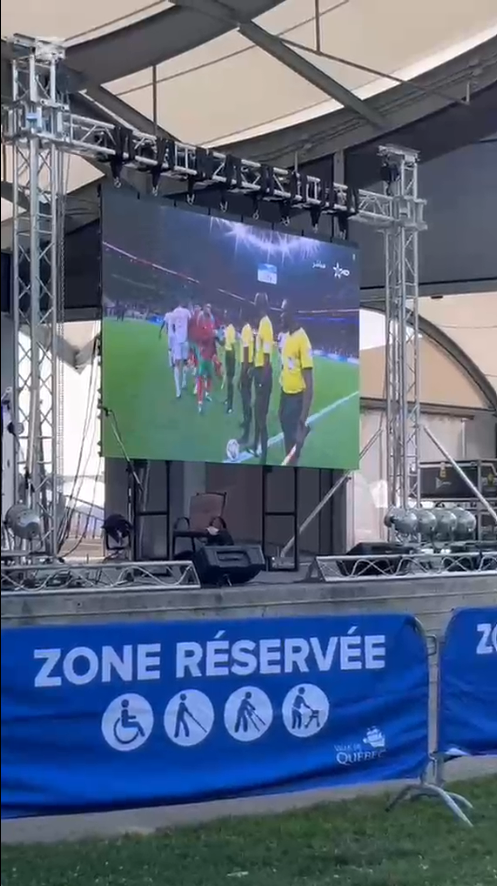 Grand écran LED extérieur sur une structure de scène diffusant un match en direct
