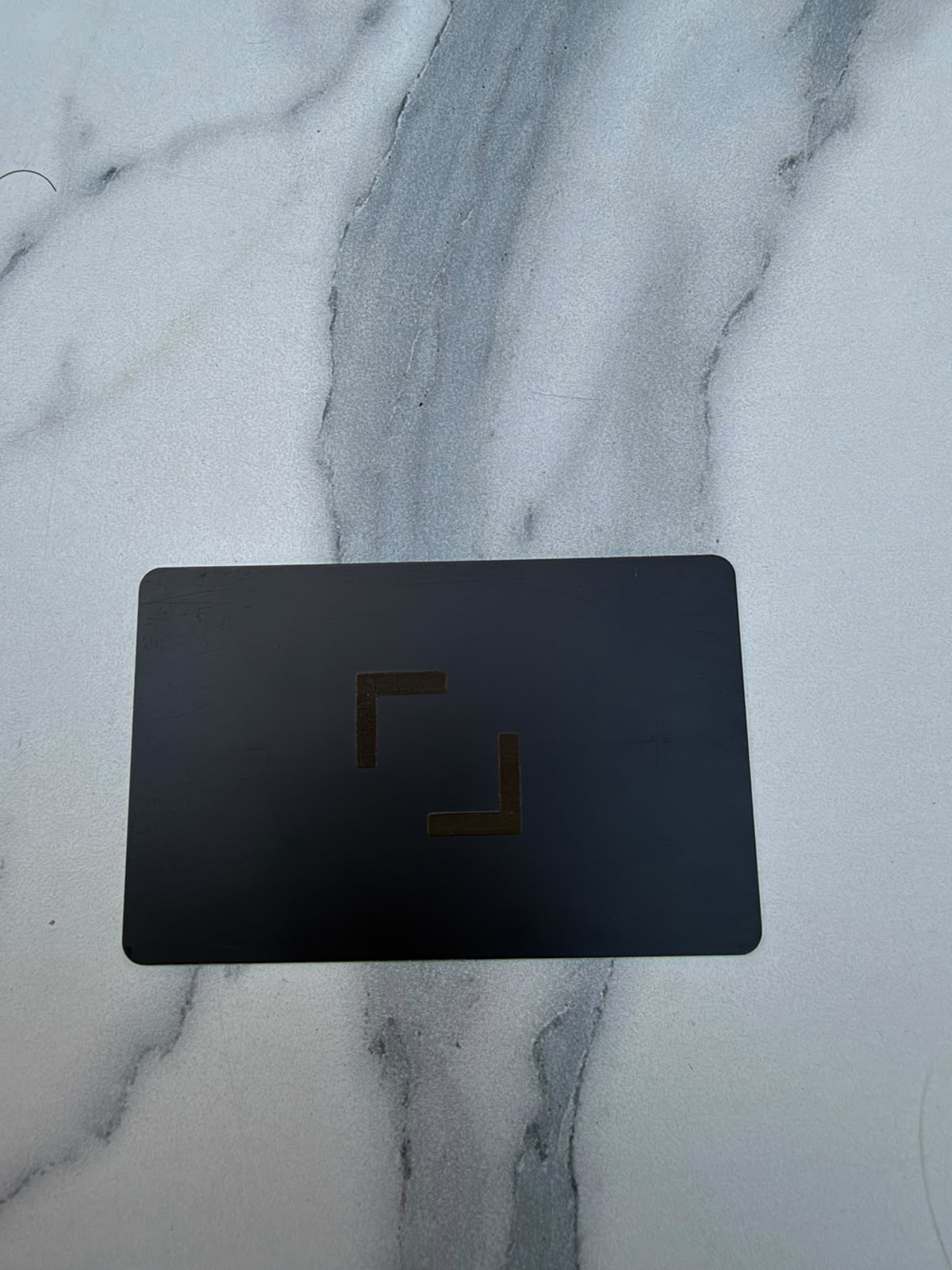 Carte NFC en métal noir avec une marque gravée en or